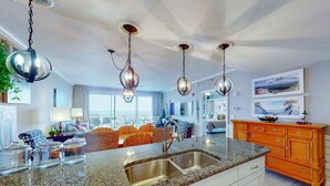 A modern kitchen with granite countertops, stainless steel sink, and pendant lighting. - Idyllic beach getaway w gulf views & swimming pool - beach access (Destin)