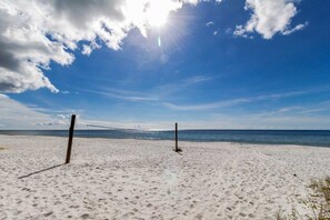 Ein Strand mit zwei Holzpfählen und einem Volleyballnetz.