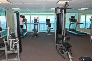 A gym with treadmills, weight machines, and exercise equipment. - Oceanfront condo with pool, hot tub & washer/dryer (Panama City Beach)