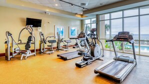 A gym with treadmills, elliptical machines, and weight machines. - Updated, beachfront condo with pool, hot tub & gym (Panama City Beach)