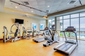 A gym with treadmills, elliptical machines, and weight machines. - Updated, beachfront condo with pool, hot tub & gym (Panama City Beach)