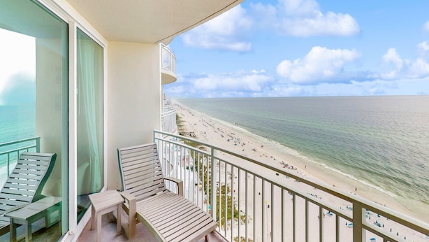 A balcony with a view of a beach and ocean. - Updated, beachfront condo with pool, hot tub & gym (Panama City Beach)