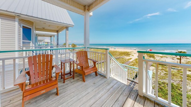 Una terraza de madera con vista a la playa.