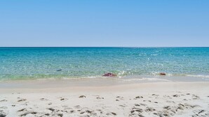 Una spiaggia con acque cristalline e sabbia bianca.