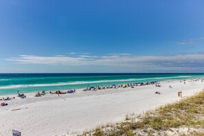 Una playa de arena blanca, agua turquesa cristalina y cielo despejado.