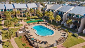 Ein Resort mit großem Pool, mehreren Balkonen und Palmen.