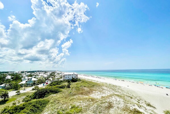 A coastal town with a beach, houses, and a clear sky. - Beachfront condo in gated resort with pools, lake access, fast WiFi & patio (Panama City Beach)