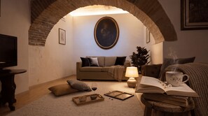 Ein gemütliches Wohnzimmer mit Fernseher, einer Couch, einem Couchtisch und einem Kamin.