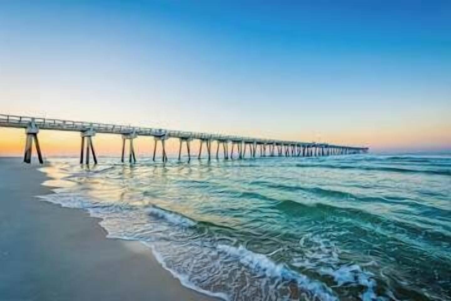 A pier extending into the ocean with a clear sky above.