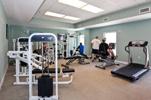 A gym with various exercise equipment, including a treadmill and weight machines. - Unique beach condo in Panama City with Gulf views, pools & fitness facility (Panama City Beach)