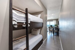 A bunk bed room with a desk and chairs in the adjacent area. - Stylish oceanfront condo w/ pool access, private W/D, ocean views, & central AC (Santa Rosa Beach)