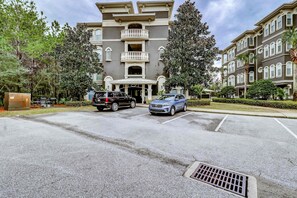 A multi-story residential building with a central entrance and a covered driveway. - Coastal chic condo steps from the sand, shared pool & central location (Santa Rosa Beach)