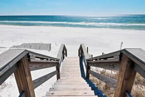 A wooden staircase leading to a beach with a clear view of the ocean. - Coastal chic condo steps from the sand, shared pool & central location (Santa Rosa Beach)