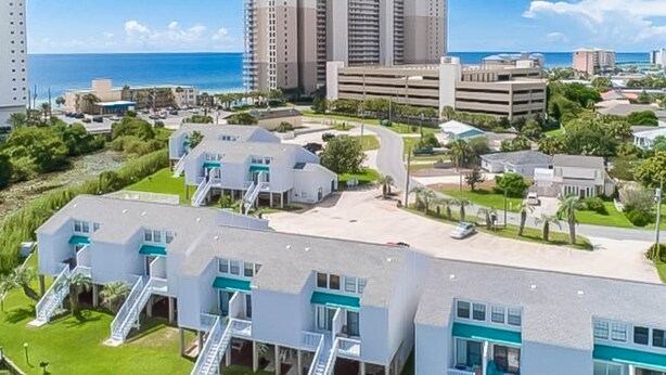 Un hôtel situé sur la côte, composé de plusieurs bâtiments à étages, doté d’un parking et offrant une vue sur l’océan.