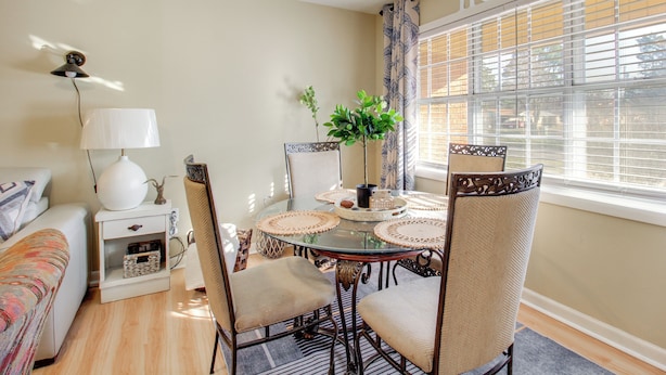 A dining area with a glass table, woven placemats, and wicker chairs. - Rocket City Retreat 4 Mi to Dtwn Huntsville! (Huntsville)