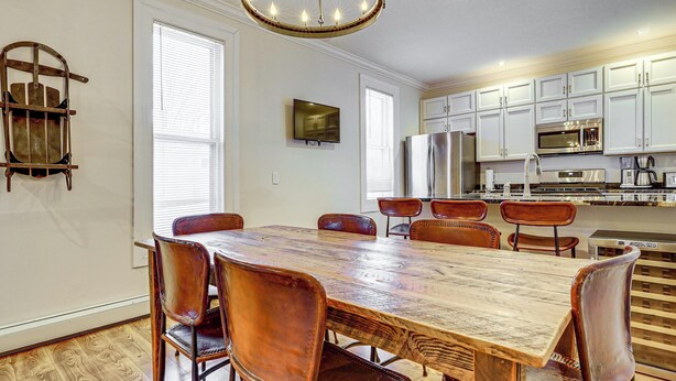 A spacious kitchen with white cabinets, a wooden dining table, and six chairs. - Stay & Play in Ellicottville Village! Home w/ Deck (Ellicottville)