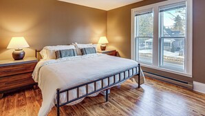 A bedroom with a bed, two bedside tables, two lamps, a window, and a view of the outside. - Stay & Play in Ellicottville Village! Home w/ Deck (Ellicottville)