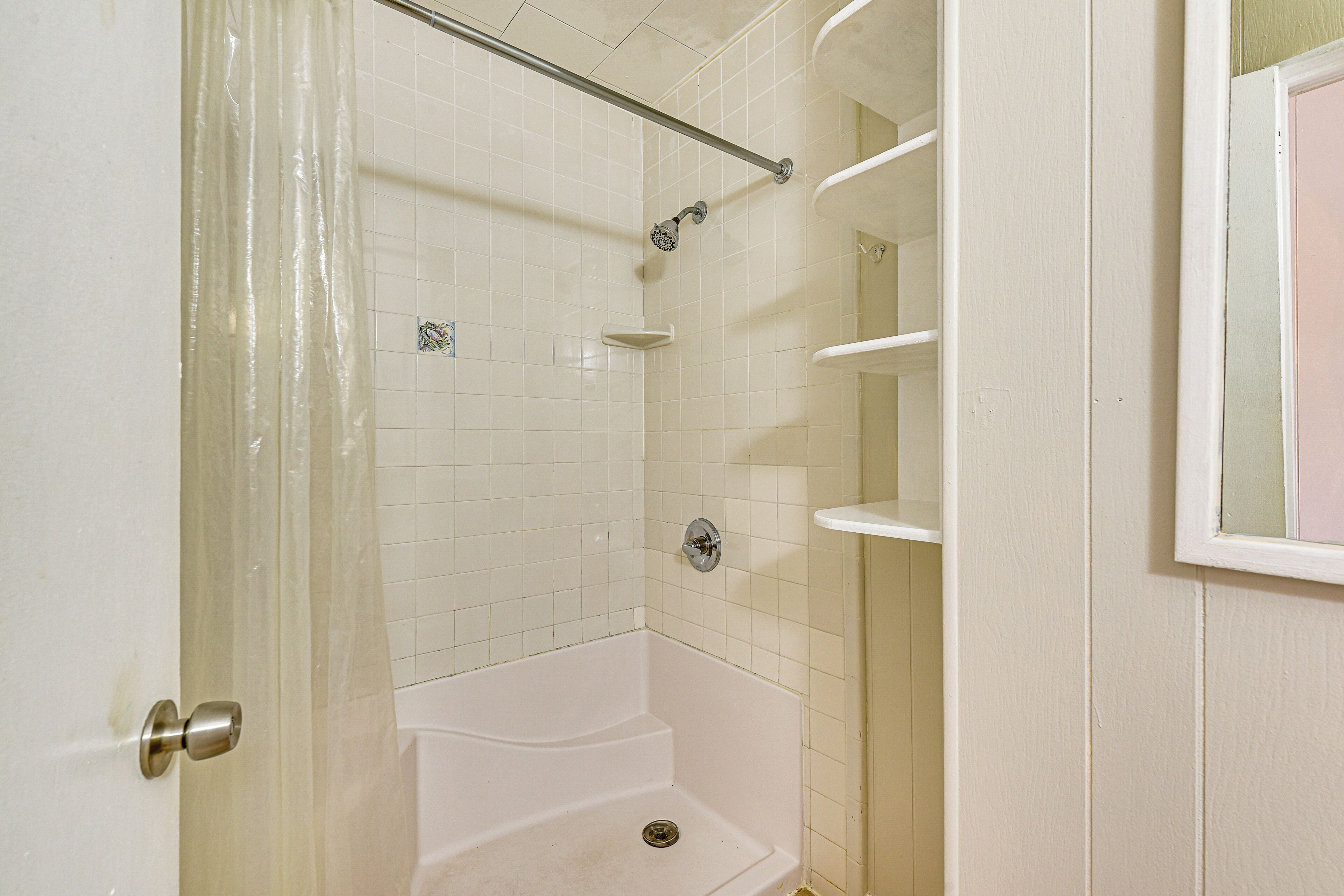 Un bagno con doccia, un water e un lavandino.