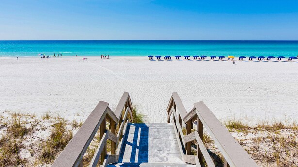 A beach with a wooden staircase leading to the sand, a clear blue sky, and a calm sea. - Destiny West - Casa Isla Paraiso (Destin)