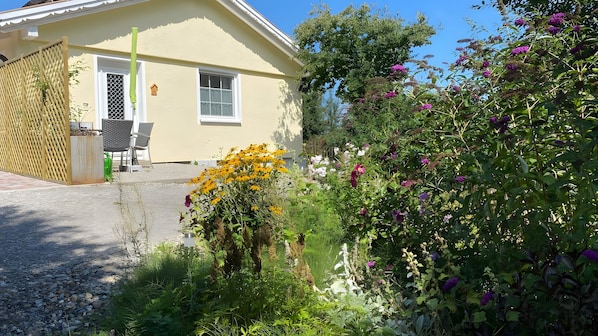 Une maison avec un jardin, une clôture en bois et une fenêtre.