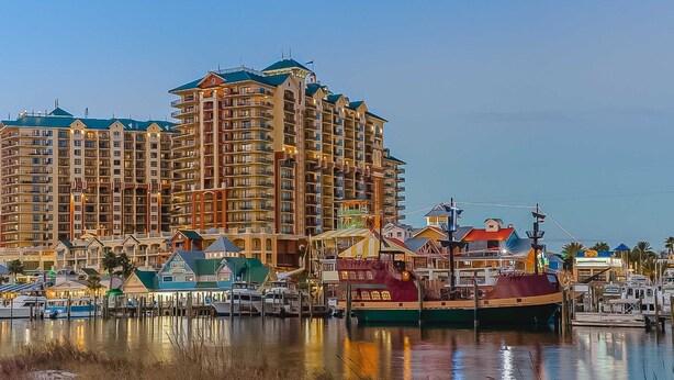 Un hôtel situé au bord de l’eau, doté de nombreux balcons, d’un port de plaisance avec des bateaux et offrant une vue dégagée sur l’eau.