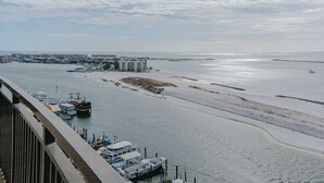 Un port de plaisance avec des bateaux amarrés, une plage de sable et des bâtiments en arrière-plan.