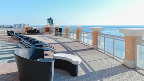 Une promenade en bord de mer avec des terrasses et une vue sur l’océan.