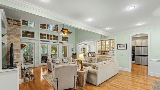 A spacious living room with a fireplace, a large sectional sofa, and a dining area with a view of the outdoors. - Pet Friendly, Chef's Kitchen, Exercise Room - 1 Fiddlers Point (Fripp Island)