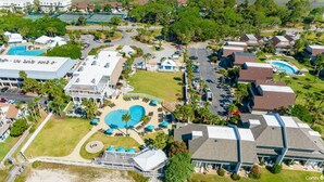 An aerial view of a resort with multiple buildings, a large swimming pool, and surrounding greenery. - Pet Friendly, Chef's Kitchen, Exercise Room - 1 Fiddlers Point (Fripp Island)