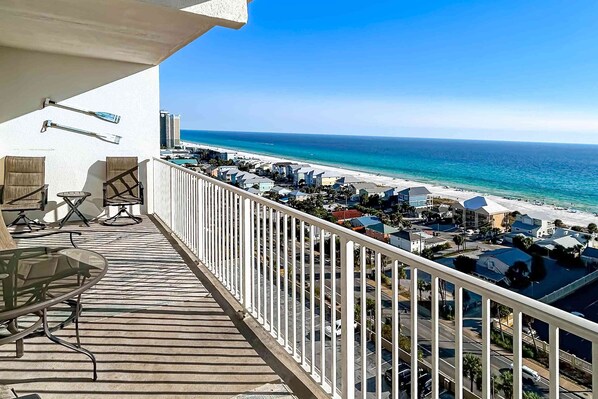 Un balcon avec vue sur une plage et l’océan.