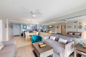 Ein modernes Wohnzimmer mit Sofa, Couchtisch und einem Essbereich mit Stühlen und Tisch.