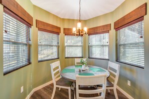 A dining area with a round table, white chairs, and a chandelier. - Blue Ridge Retreat: 1 Mi to Kingwood Golf (Clayton)