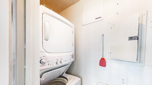 A laundry room with a front-loading washing machine and a dryer. - Waterfront condo with a scenic balcony and AC - pool, gym, and grill access (Panama City Beach)