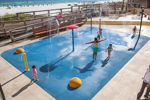A water play area with a blue surface, yellow safety balls, and a wooden deck overlooking a beach. - 17th-floor Gulf-front condo with indoor & outdoor pools, hot tub & on-site dining (Destin)
