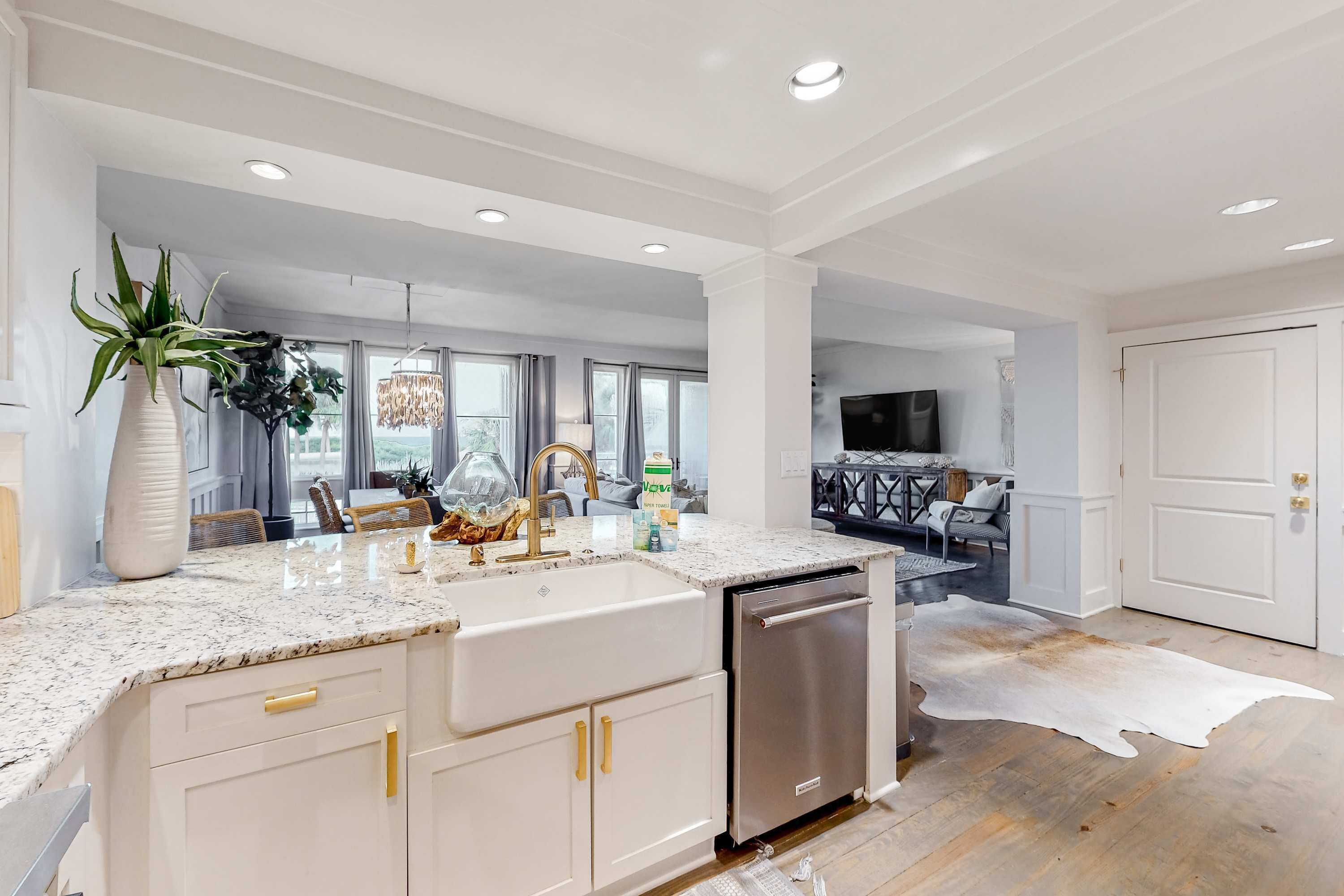 A modern kitchen with white cabinetry, a granite countertop, and a stainless steel dishwasher.