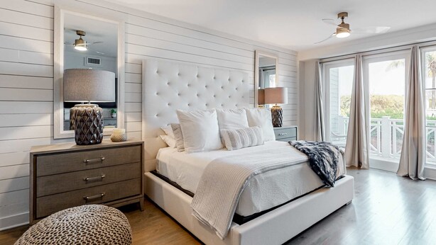 A bedroom with a large bed, a nightstand, a dresser, and a window with curtains. - Gorgeous, updated condo with balconies, pool, & great location near 30A (Alys Beach,)