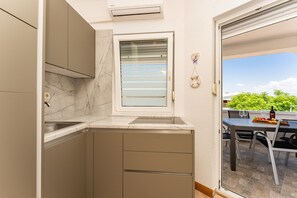 A compact kitchen with a built-in window, a sink, and a small countertop. - Apartment Lavaran 4 (Vir)