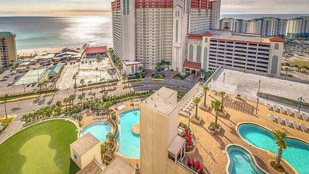 A resort with multiple swimming pools, a beach, and a large hotel building. - Beach condo with WiFi, amazing views, hot tub, and pools (Panama City Beach)