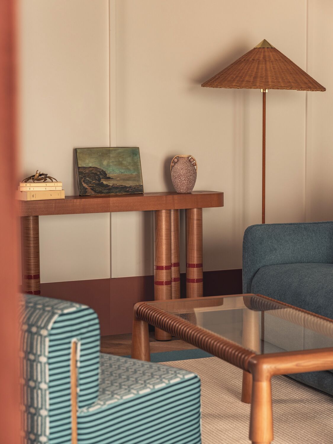 Una stanza con un divano, un tavolino da caffè, un comodino con una lampada e un quadro.