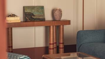Una stanza con un divano, un tavolino da caffè, un comodino con una lampada e un quadro.
