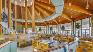 A spacious restaurant with high wooden ceilings, large windows, and a variety of seating arrangements. - Golf lovers’s condo with golf, 11 pools, hot tubs, gym, tennis, pickleball, W/D (Panama City Beach)