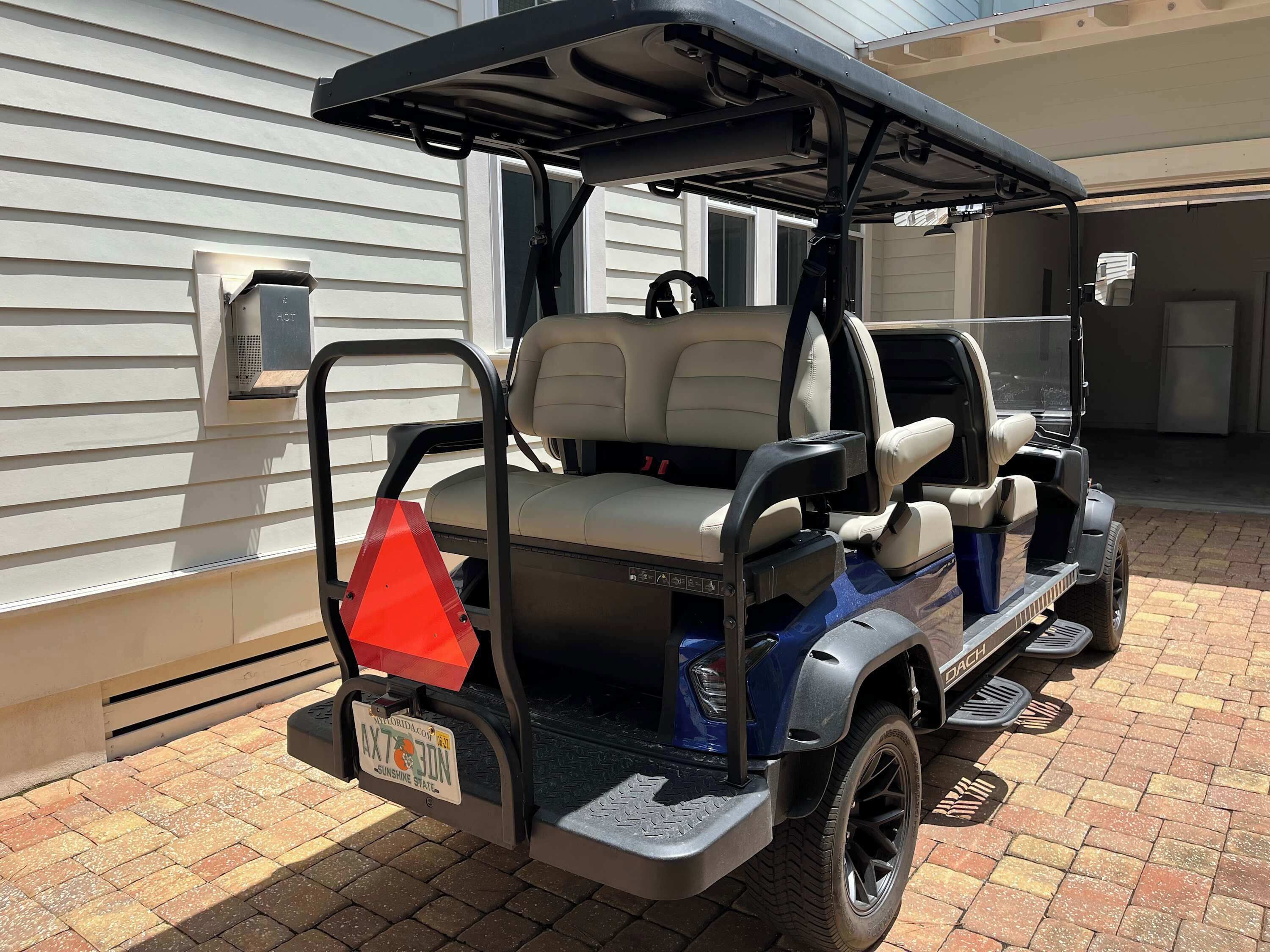 A golf cart parked in front of a building with a garage door.