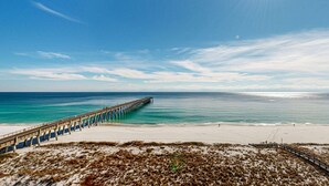 A beach with a wooden pier extending into the ocean. - 7th-floor bright, open condo - close to dining with Gulf front views (Navarre Beach)
