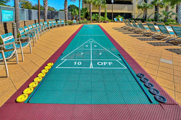 Uma quadra de shuffleboard com áreas de pontuação numeradas e borda vermelha.