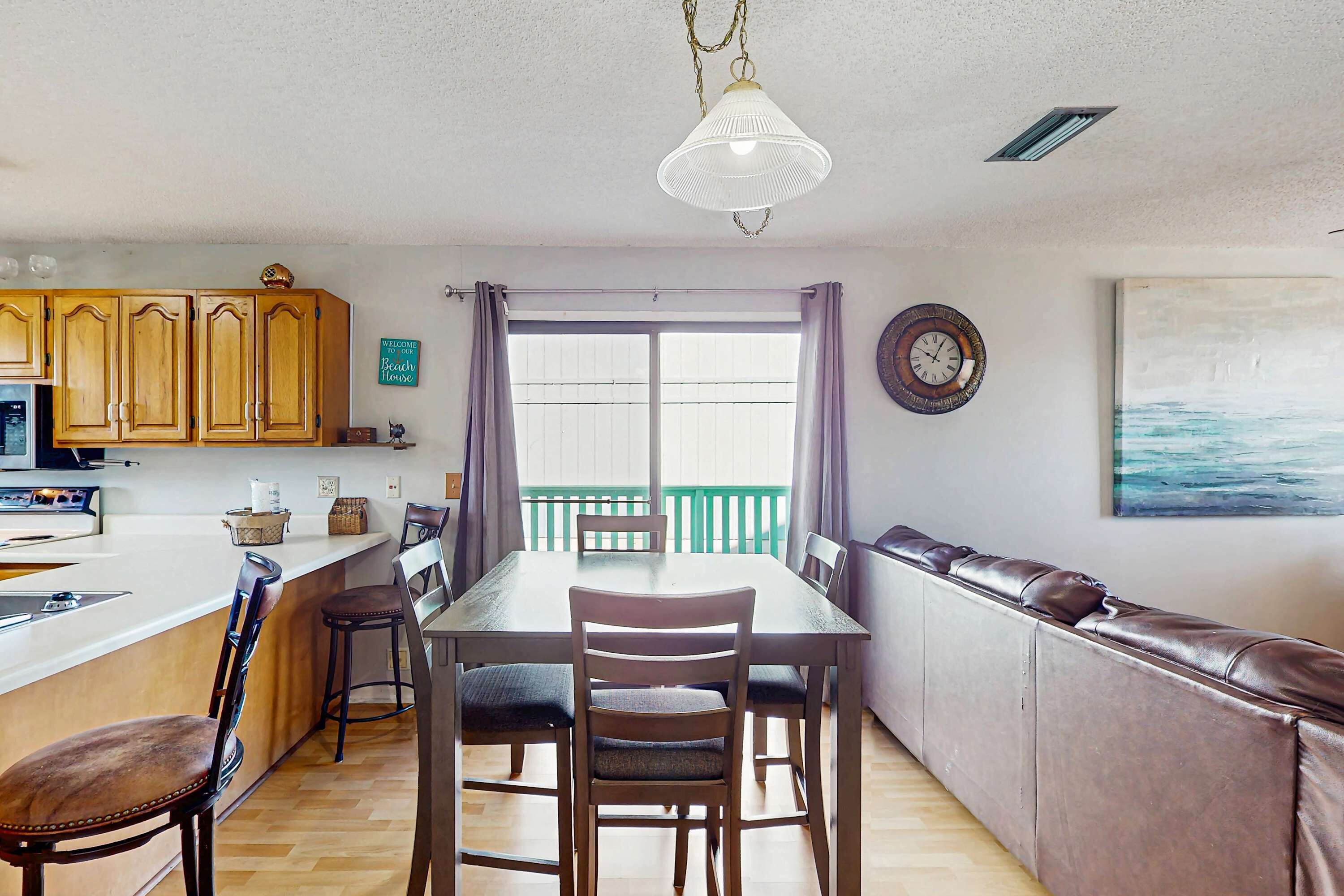Una cocina compacta con armarios de madera, una mesa de comedor y una barra.