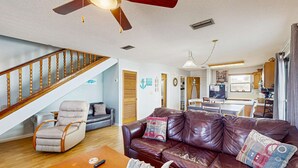 A living room with a brown leather sofa, a wooden coffee table, a recliner, and a ceiling fan. - Relaxing retreat with Lake Powell views, dock access, 2 pools, & screened patio (Panama City Beach)