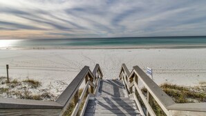 A wooden staircase leading to a beach with a clear view of the ocean. - Inviting beach view condo with balcony, amazing pool, gym, & W&D (Miramar Beach)