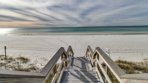 A wooden staircase leading to a beach with a clear view of the ocean. - Inviting beach view condo with balcony, amazing pool, gym, & W&D (Miramar Beach)