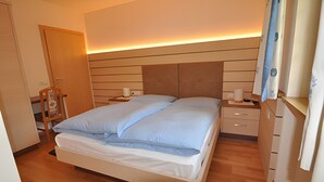 A bedroom with a bed, bedside tables, a wardrobe, and a nightstand. - Villa Konstanze Apartment with Mountain View, Private Terrace and Wi-Fi (Plan Da Tieja)