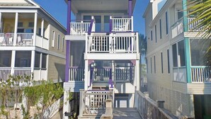 A coastal residential area with multi-story houses featuring balconies and a narrow walkway.
